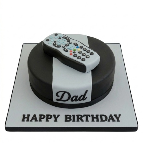 Round black and grey fondant cake with a detailed edible TV remote control on top, on a square board with 'Happy Birthday' written.