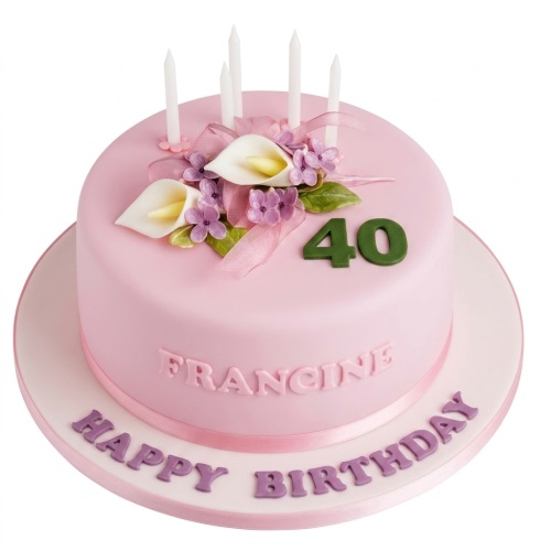 Pink round birthday cake with white and purple sugar flowers, green leaves, and white candles.