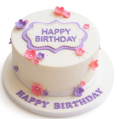 Round white birthday cake with pink and purple fondant flowers and 'Happy Birthday' message.