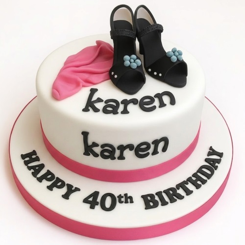 Two-tier white birthday cake with black high heel shoes, pink draped fabric, and pink ribbon.