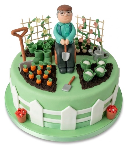 Green gardening theme birthday cake with a gardener figure, vegetables, and a white picket fence.