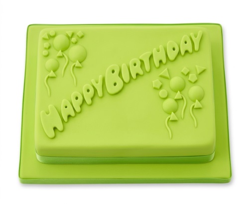 Lime green rectangular birthday cake with 'Happy Birthday' text and balloon and geometric shape decorations.