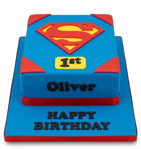 Two-tier blue Superman birthday cake with red and yellow logo, custom age, and personalised name.