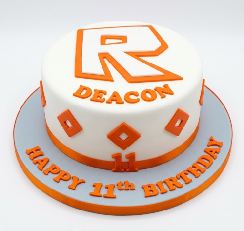 Round white and orange Roblox themed birthday cake with custom age and name.