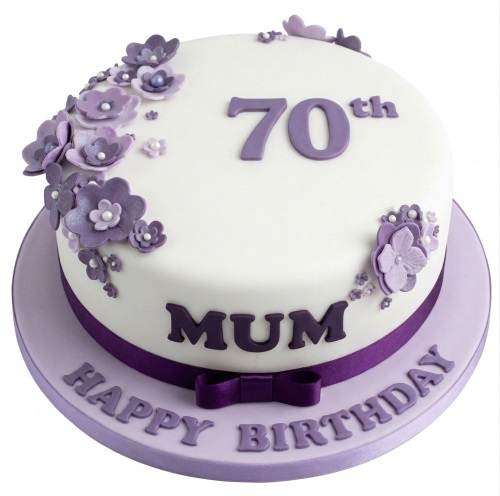 White birthday cake with purple sugar flowers, purple ribbon, and custom age topper.