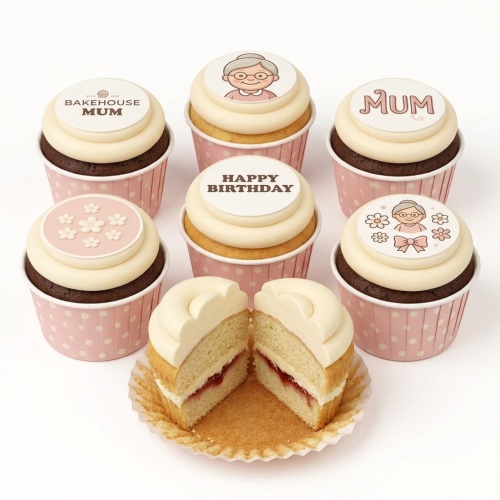 Birthday cupcakes for Mum with cream icing, pink polka dot cases, and toppers featuring a grandma character, 'MUM' text, and white flowers.