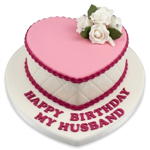Heart shaped pink and white birthday cake with white sugar roses and quilted sides, ready for a custom message.