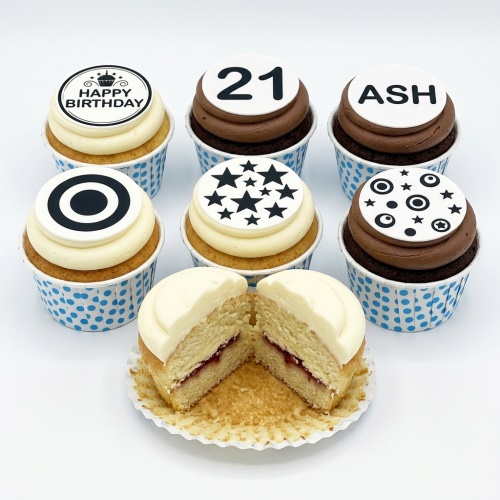 A selection of birthday cupcakes with white and chocolate frosting, topped with custom age, name, and patterned edible discs.