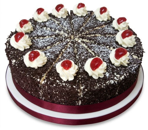 Round Black Forest cake with chocolate sprinkles, cream swirls, and red cherry toppings, pre-sliced.