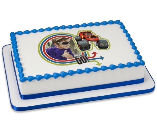 Rectangular white birthday cake with blue border, featuring Blaze the Monster Machine and a child's photo.