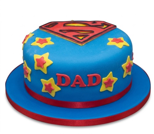 Round blue Superman birthday cake with red 'S' logo and yellow stars, with 'DAD' written on the side.