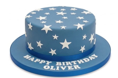 Blue fondant birthday cake with white stars and a blue ribbon.