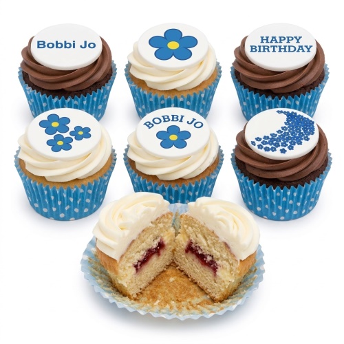 A selection of blue floral birthday cupcakes with white and chocolate icing, some with custom name and 'Happy Birthday' toppers.