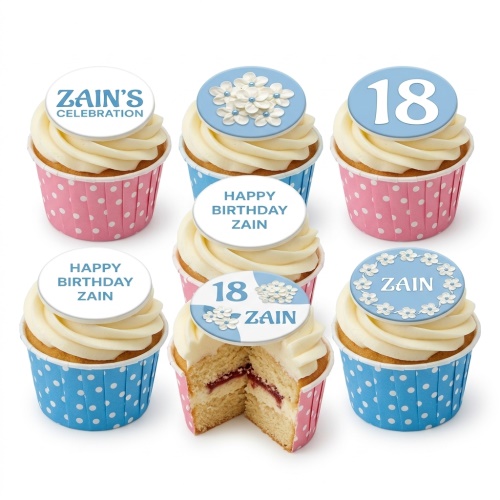 White iced cupcakes in blue and pink polka dot wrappers, with custom age and name toppers, some featuring white floral designs.
