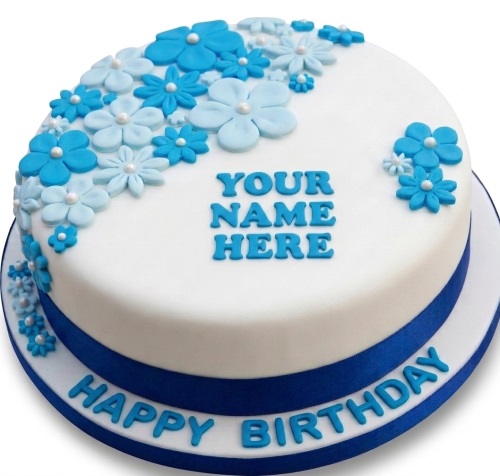 Round white birthday cake with blue and light blue fondant flowers and a personalised name area.