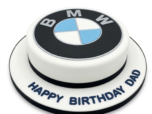 Round white fondant cake with a prominent black, white, and blue BMW logo on top and a dark blue personalised message on the board.