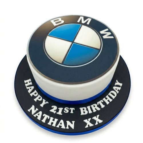 Round white and dark blue cake with a large BMW logo on top and a custom message on the board.