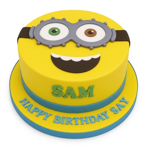 Round yellow Minion character birthday cake with goggles, smile, and personalised message.