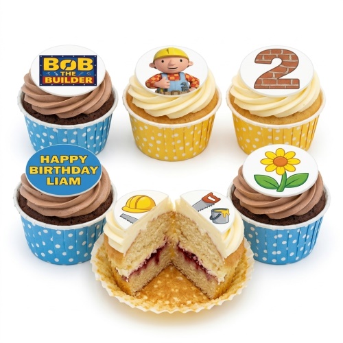 A selection of Bob the Builder themed cupcakes with blue and yellow polka dot wrappers, featuring Bob the Builder character, logo, brick number 2, flower, and construction tool toppers, with one cupcake cut to show a jam filling.