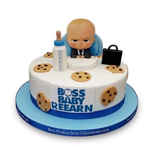 Round white Boss Baby themed birthday cake with a Boss Baby figurine, baby bottle, briefcase, and edible cookies.