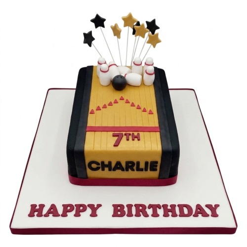 Bowling alley themed birthday cake with pins, bowling ball, and star toppers, on a white cake board.