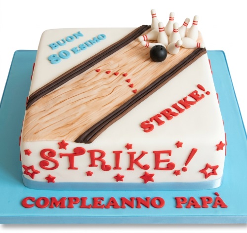 White square bowling alley themed birthday cake with pins, ball, and red 'Strike!' message.