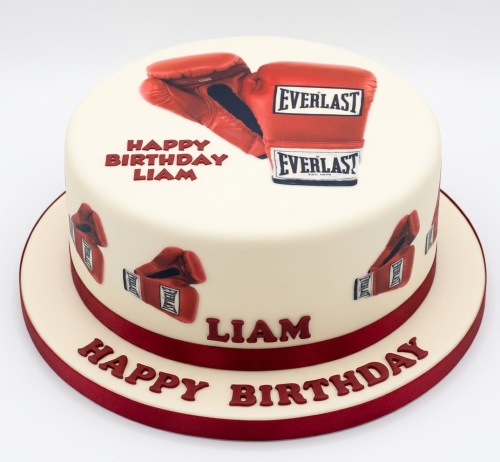 Round cream birthday cake with red Everlast boxing gloves and "Happy Birthday" message.