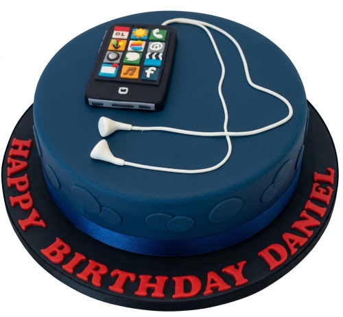 Round dark blue birthday cake with an edible smartphone and white earphones on top.
