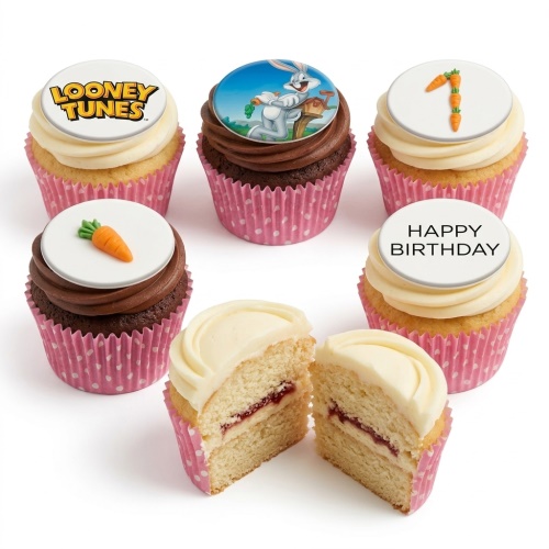 Six Looney Tunes themed cupcakes with Bugs Bunny, logo, carrots, and 'Happy Birthday' toppers in pink polka dot wrappers.