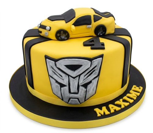 Yellow Transformers birthday cake with 3D car, Autobot logo, and custom age topper.