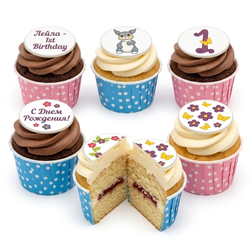 Selection of personalised birthday cupcakes with bunny, number one, floral, and butterfly toppers in pink and blue wrappers.