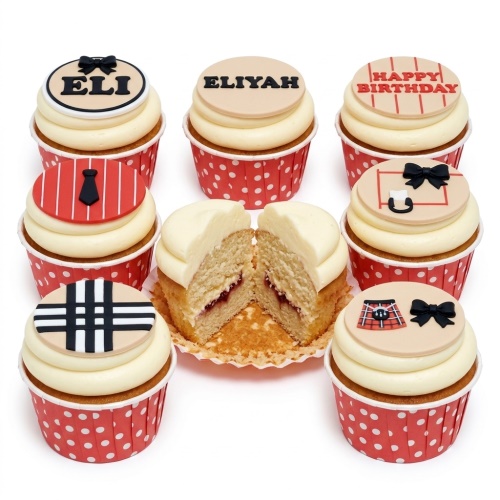 A selection of designer-inspired birthday cupcakes with various fashion-themed edible toppers including plaid, bows, ties, and a handbag, with some personalised with names and a 'Happy Birthday' message.