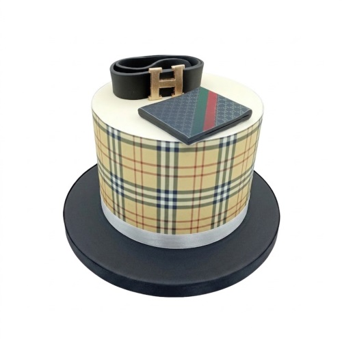 Round single-tier cake with Burberry plaid pattern, Gucci-style topper, and Hermes-like belt buckle.