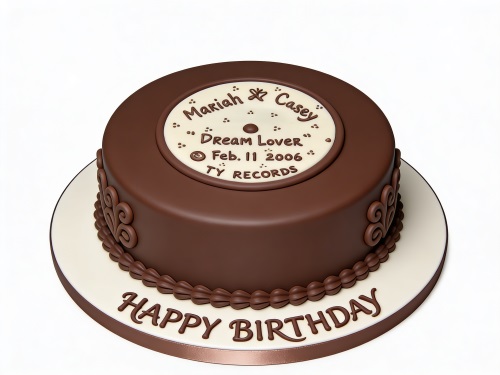 Round brown birthday cake with a white vinyl record label on top, featuring custom text and scrollwork on the sides.
