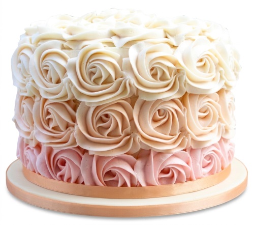 Round cake with ombre buttercream rosettes in white, peach, and pink, with a ribbon.