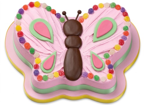 Pink butterfly-shaped birthday cake with chocolate body, green and pink wings, and colourful candy dots.
