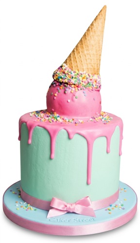 Single-tier mint green cake with pink drip icing, an upside-down ice cream cone, and colourful sprinkles.