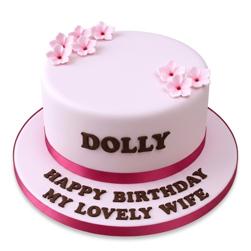 Round pink fondant birthday cake with delicate pink sugar flowers and a custom message.