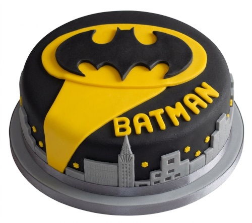 Round black and yellow Batman themed birthday cake with Bat-Signal logo and Gotham cityscape.