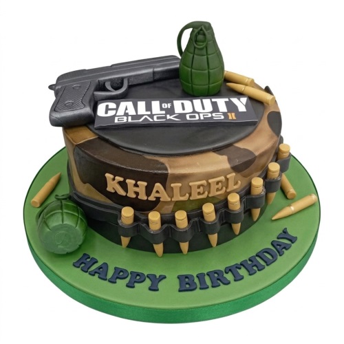 Round Call of Duty Black Ops II themed birthday cake with camouflage, gun, grenades, and personalised name.