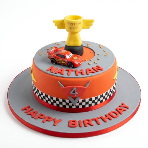 Round orange and grey Lightning McQueen birthday cake with Piston Cup and custom age topper.