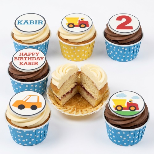 A selection of kids construction themed birthday cupcakes with digger and car toppers, custom age '2' and personalised name 'Kabir' examples.