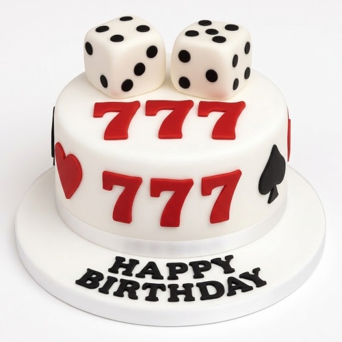 White birthday cake with red 777s, dice, and card suit decorations.