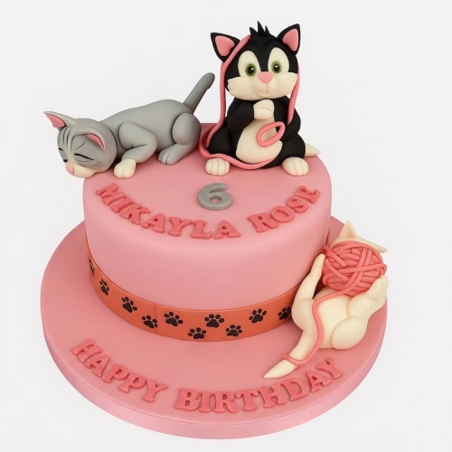 Two-tier pink kitten theme birthday cake with cat figurines, yarn, paw prints, and a custom age topper.