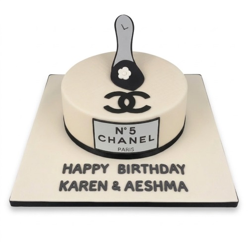Round cream Chanel themed birthday cake with black logo, N°5 label, and high heel shoe.