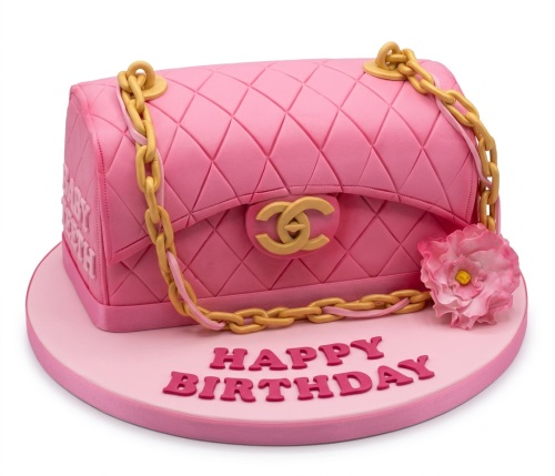 Pink quilted Chanel-style handbag birthday cake with gold chain and sugar flower on a pink board.
