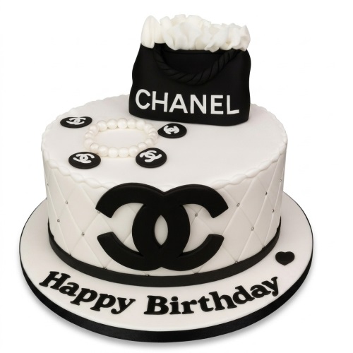 White round cake with black Chanel logo, black Chanel handbag topper, and pearl-effect decoration.