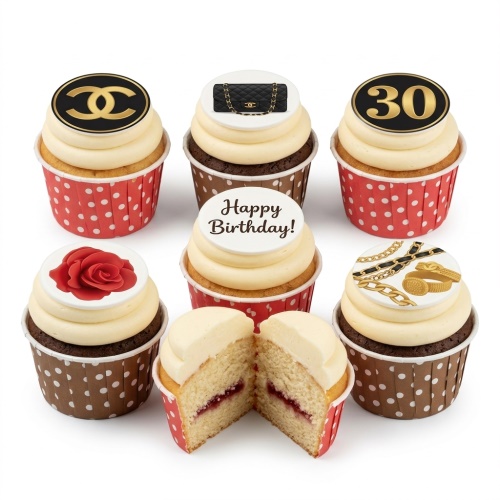 Cupcakes with designer-inspired toppers, including a Chanel-style logo, black quilted handbag, gold chains, a red rose, and a 'Happy Birthday' message.