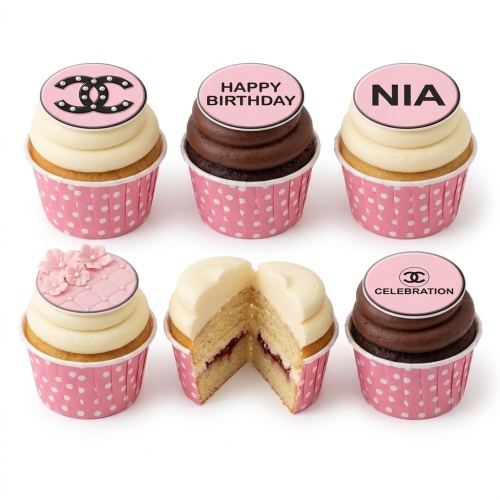 Set of designer-inspired cupcakes with pink and black toppers, some with a double C logo, floral details, and pink polka dot cases.