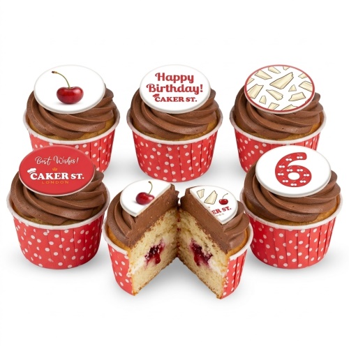 Six cupcakes with chocolate frosting, red polka dot wrappers, and edible toppers including cherries, white chocolate shards, 'Happy Birthday!', 'Best Wishes!', and a number '6' made of cherries.